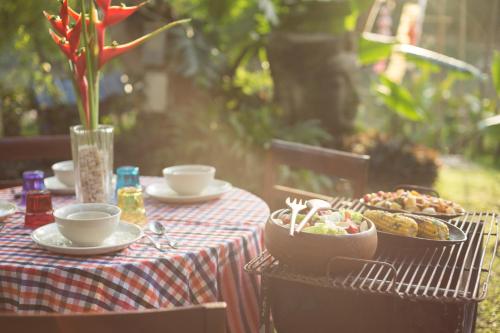 a table with plates of food and a bowl of food at Villa San Pee Seua in Chiang Mai