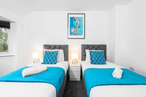 two beds in a bedroom with blue and white at Deluxe Four Bedroom House - Garden - Parking - Sleeps 7 - Netflix - 559T in Birmingham