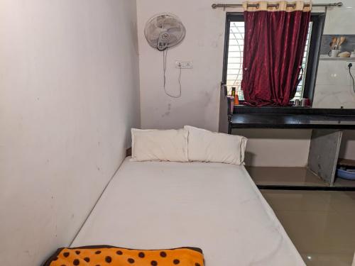 a small room with a bed and a fan at Jay Kuber Home stays in Garudeshwar