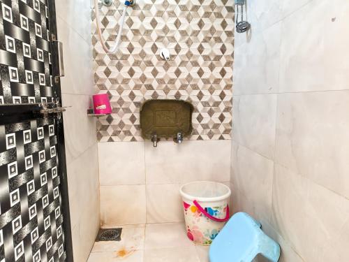 a small bathroom with a trash can and a shower at Jay Kuber Home stays in Garudeshwar