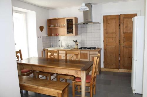 - une cuisine avec une table et des chaises en bois dans l'établissement Gîte du Penon - Aillon-Le-Jeune, Margériaz - Maison de village, à Aillon-le-Jeune