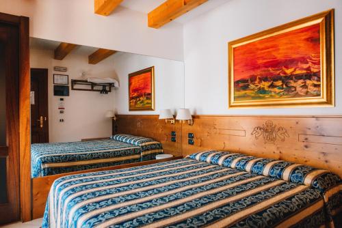 dwa łóżka w pokoju z obrazem na ścianie w obiekcie Arciduca Charming House Room & Breakfast w Arco