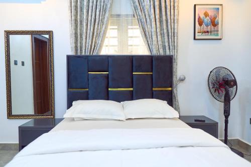 a bedroom with a large bed and a mirror at Lush Meadows Apartments in Kadobunkuro
