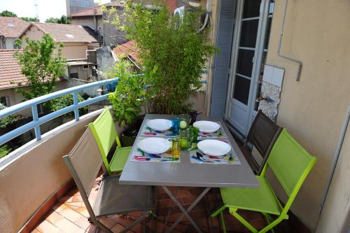 a table and chairs sitting on a balcony with a table and chairs at Appartement Les Hortensias in Avignon