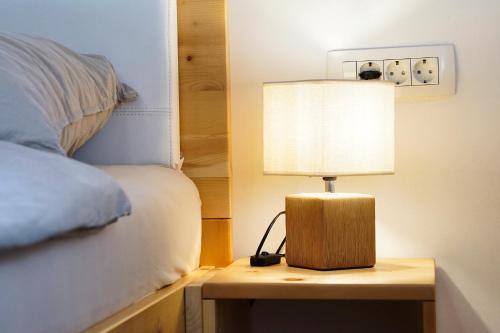 a lamp sitting on a table next to a bed at Old Mill House in Bohinj