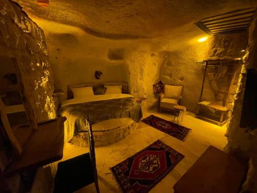 a bedroom with a bed and a chair in a room at Lubberona Cave Cappadocia in Nar