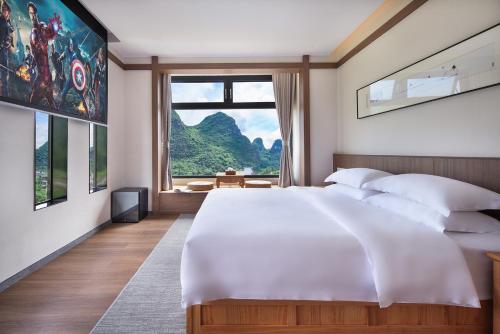 1 dormitorio con cama grande y ventana grande en The Giggling Tree en Yangshuo