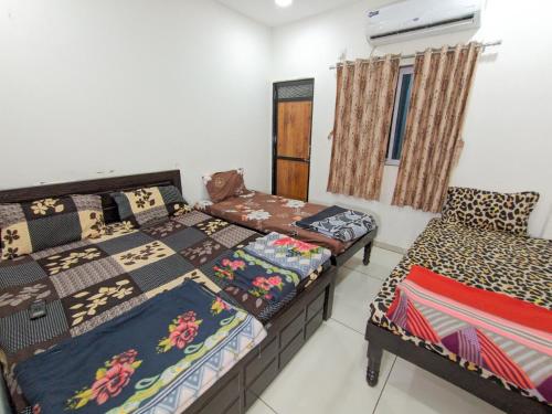 a bedroom with two beds and a window at Veer Homestay in Garudeshwar