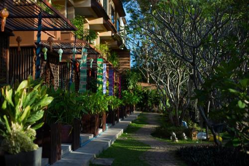 a walkway in front of a building with plants at Villa San Pee Seua in Chiang Mai