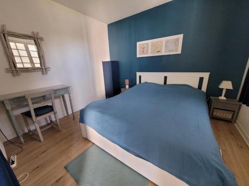 - une chambre bleue avec un lit et une table dans l'établissement Parc Cordier - Trouville sur Mer, à Trouville-sur-Mer