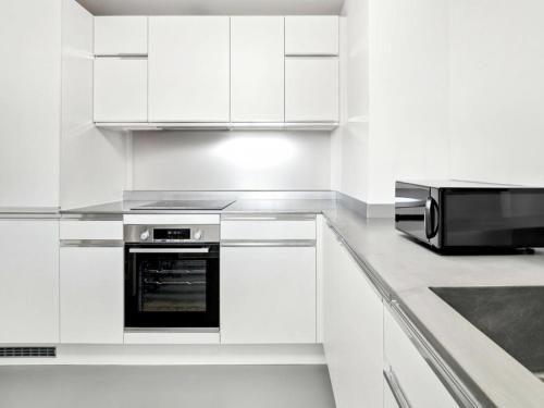kuchnia z białymi szafkami i kuchenką mikrofalową w obiekcie Beautiful Apartment by Piccadilly Circus w mieście Edmonton