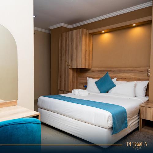 マプトにあるPEROLA HOTElの青をアクセントにした大型ベッドが備わるホテルルームです。