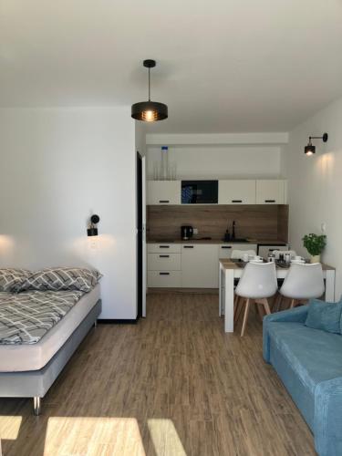 ein Schlafzimmer mit Bett und ein Wohnzimmer in der Unterkunft AGAT Pokoje Gościnne Apartamenty in Pobierowo