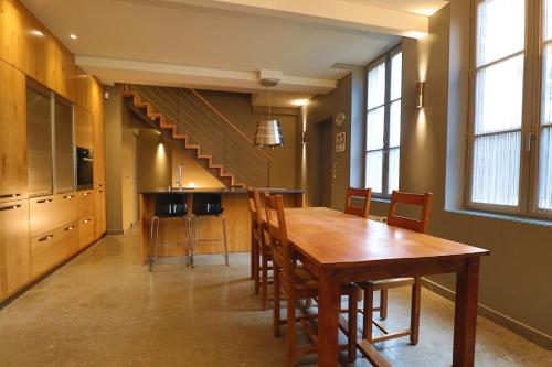 ein Esszimmer mit einem Holztisch und einer Treppe in der Unterkunft Le Chalet Saint Vincent in Seurre