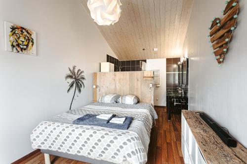 une chambre avec un grand lit avec une tête de lit en bois dans l'établissement Maison de vacances hyper centre, à Sainte-Marie de Ré