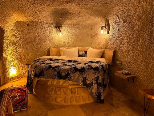 ein Schlafzimmer mit einem Bett in einer Ziegelwand in der Unterkunft Lubberona Cave Cappadocia in Nar