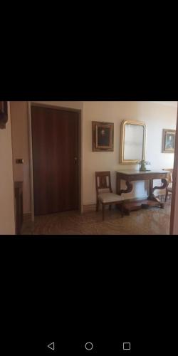 Habitación con espejo, mesa y silla en Corso Roma Apartments en Cirò Marina