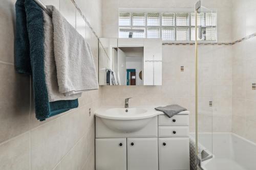 Baño blanco con lavabo y espejo en Lovely flat in Paris en París