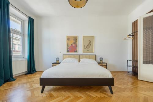 a white bedroom with a bed and two windows at Imperial City Apartment in Vienna