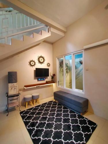 a living room with a couch and a large window at Villa Gamping Favika Batu in Batu
