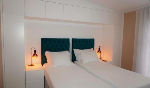 1 cama blanca con 2 almohadas y 2 lámparas en Lux'Otel City Lodge, en Barcelos