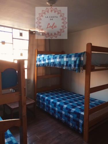 sypialnia z łóżkiem piętrowym z biało-niebieską pościelą w obiekcie La casita de Lulú w mieście Arequipa