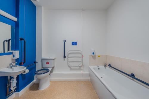 a bathroom with a tub and a toilet and a sink at Wookey Hole Hotel in Wells