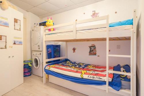 een slaapkamer met 2 stapelbedden en een wasmachine bij de Skilbank in Makkum