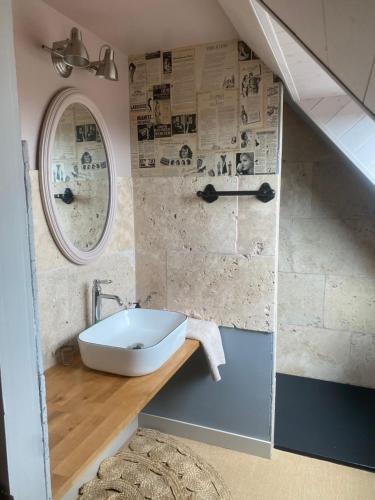 une salle de bain avec un lavabo et un miroir dans l'établissement les gîtes de Blandines II, à Peumérit