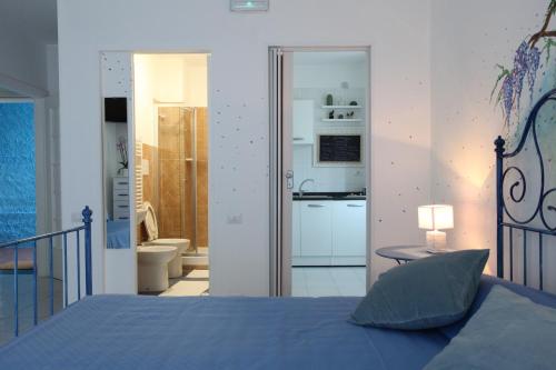 a bedroom with a blue bed and a bathroom at Jungle Rooms in Cetara