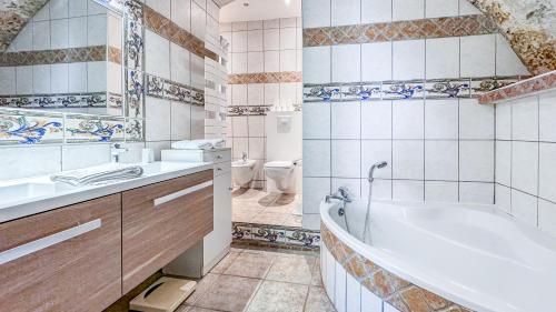 a bathroom with a tub and a sink and a toilet at Très beau mas provençal proche Alpilles in Barbentane