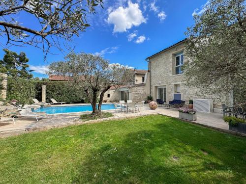 une cour avec une piscine et une maison dans l'établissement Très beau mas provençal proche Alpilles, à Barbentane