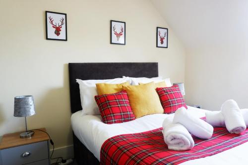 a bedroom with a bed with red and yellow pillows at Jacobite house in Inverness