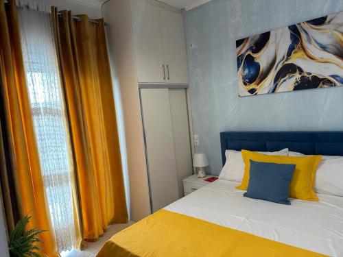a bedroom with a bed with yellow and blue pillows at Katerina's Relaxing Apartment in Sarandë