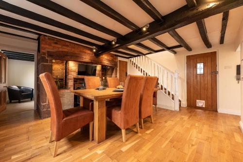 a dining room with a wooden table and chairs at Pass the Keys Charming Cottage Stunning Views in Cheswardine