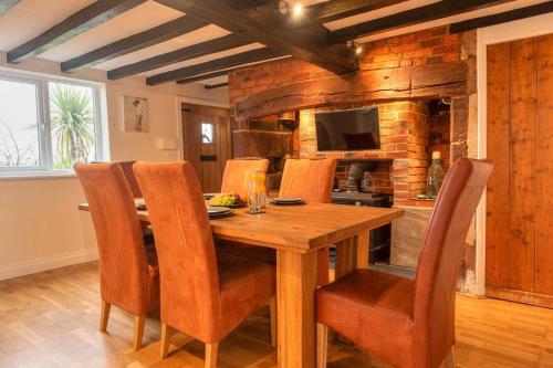 a dining room with a wooden table and chairs at Pass the Keys Charming Cottage Stunning Views in Cheswardine