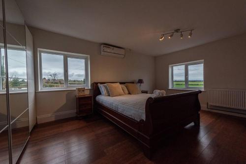 a bedroom with a bed and two windows at Pass the Keys Charming Cottage Stunning Views in Cheswardine