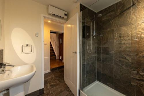 La salle de bains est pourvue d'un lavabo et d'une douche. dans l'établissement Pass the Keys Charming Cottage Stunning Views, à Cheswardine