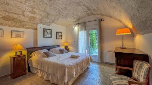 a bedroom with a bed and a chair and a window at Très beau mas provençal proche Alpilles in Barbentane