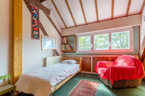1 dormitorio pequeño con 1 cama y 1 silla en Maison trévignon à 100m de la plage, en Trégunc