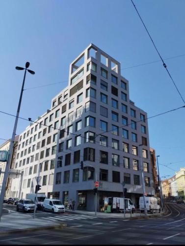 a tall white building with cars parked in front of it at My Mozartova in Prague
