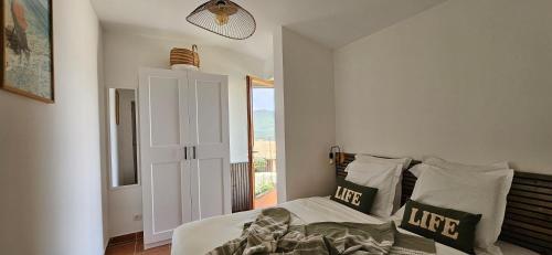 セラ・ディ・フェロにあるMini Caseddu T2, Alba Rossa avec Piscine & vue merのベッドルーム1室(ベッド1台、大きな窓付)