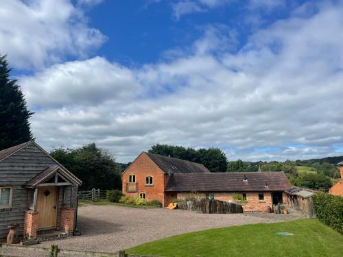 a barn and a house with a driveway at Stunning rural Barn Conversion in Worcester