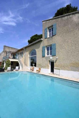 une grande piscine devant un immeuble dans l'établissement Magnifique Prieuré XIIIs dans un village fortifié., à Châteauneuf-de-Gadagne