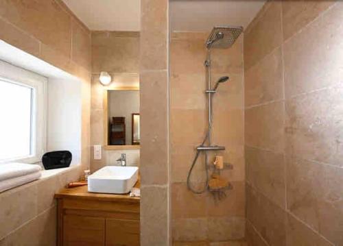 une salle de bain avec un lavabo et une douche dans l'établissement Magnifique Prieuré XIIIs dans un village fortifié., à Châteauneuf-de-Gadagne