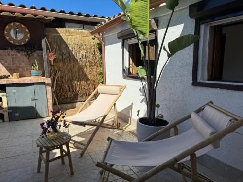 une terrasse avec 2 chaises et une plante dans l'établissement Casita Louise Maison de plage bohème, à Lucciana