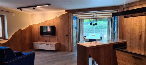 a living room with a desk and a tv in a room at Appartamenti Home Service in Arabba
