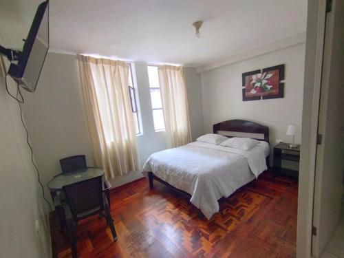 a bedroom with a bed and a television in it at Hotel la encantada in Cajamarca