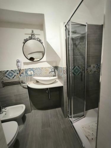 Un baño con ducha, lavabo y espejo. en da Nonna Maria, en Scicli