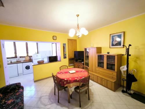 a dining room with a table and a kitchen at La Bretonne in Feriolo